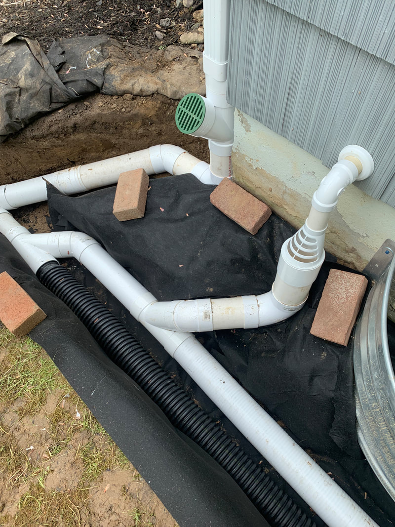 Drainage solutions to fix water problems around the outside of a home and yard. How to install underground drainage system picture. DIY exterior house ideas for drainage, basement waterproofing, plumbing, and landscaping. 